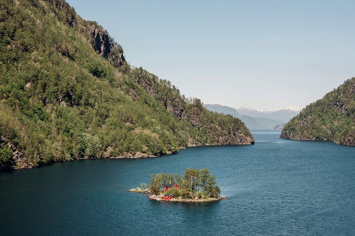 røde hus på en liten øy i en norsk fjord