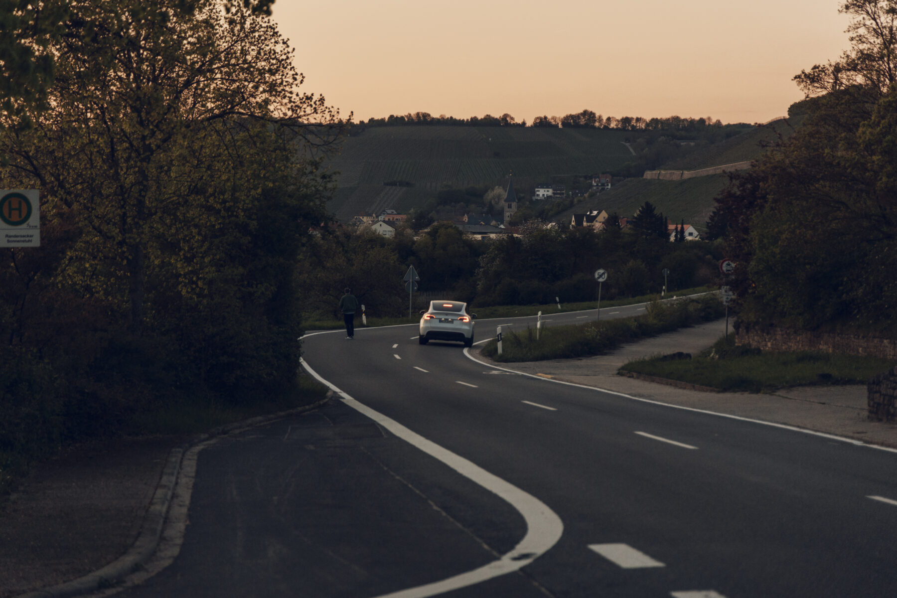 Ein weißer Tesla Y fährt und bricht