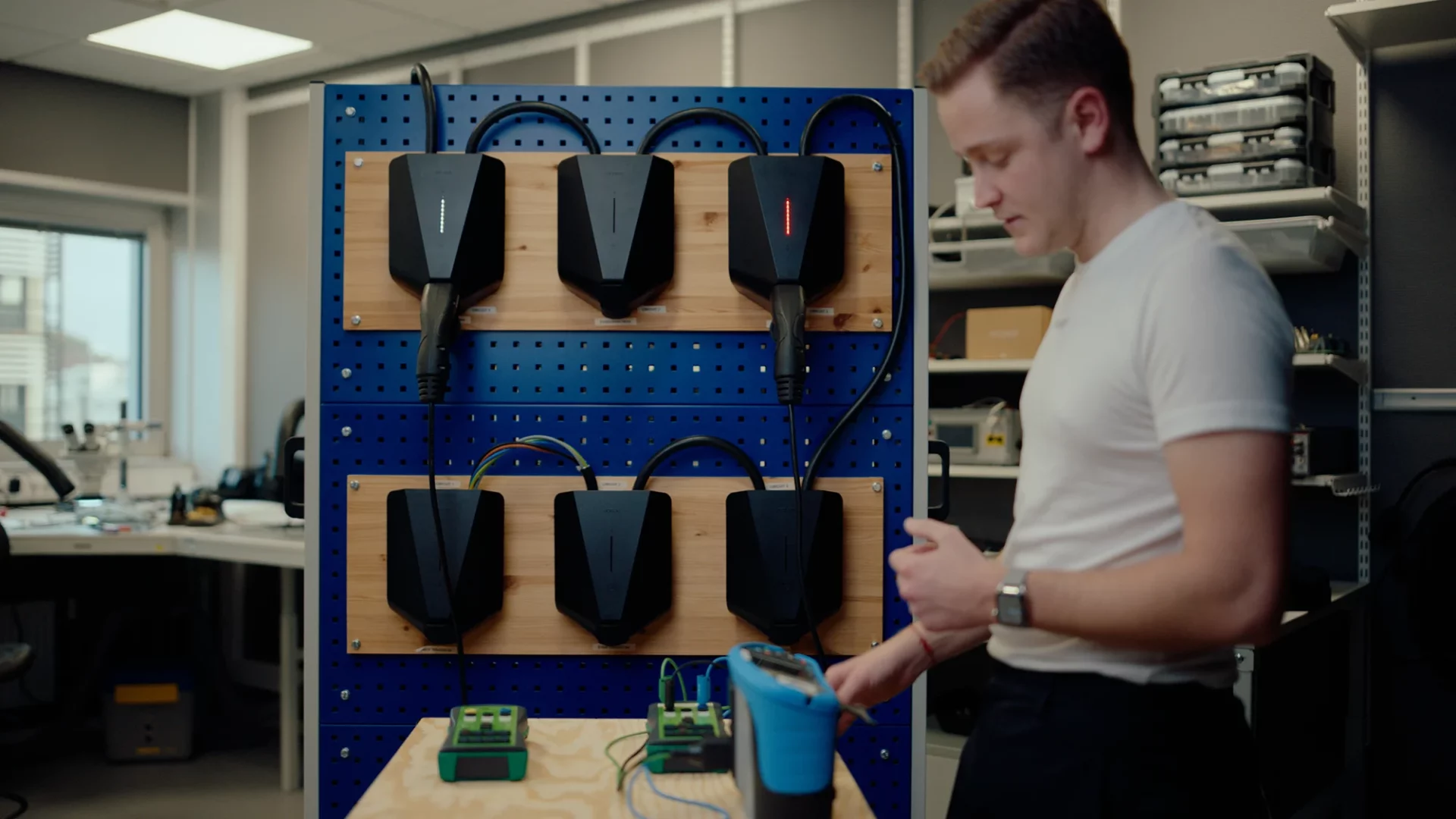 Andreas Jotorp tests the RCD on EV chargers mounted on a wall in the lab