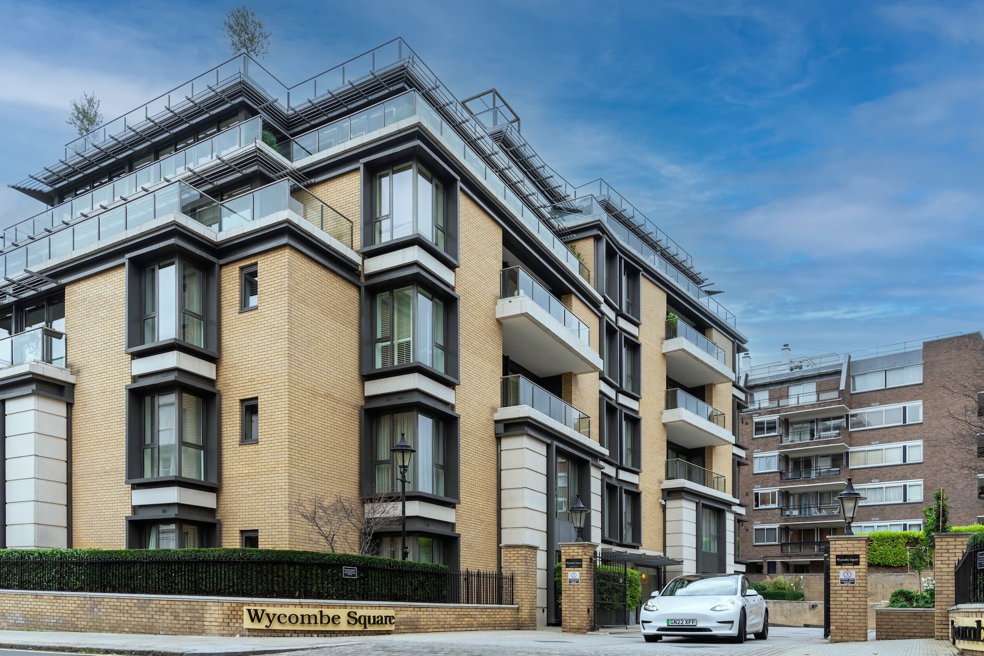 The apartment building Wycombe Square with a Tesla Model 3 outside