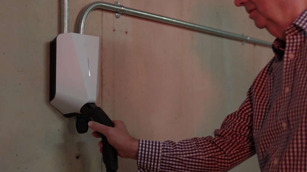 Roger connecting the cable to the white EV charger