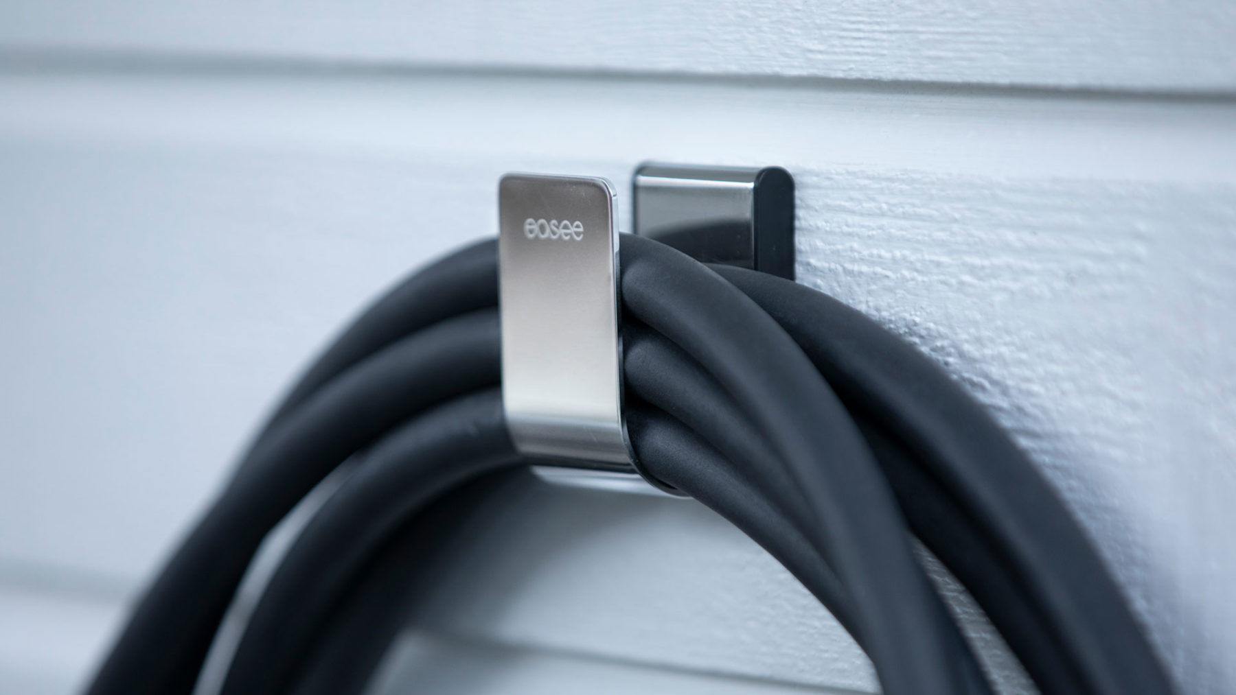 Charging cable hanging on a chrome Easee U-Hook.