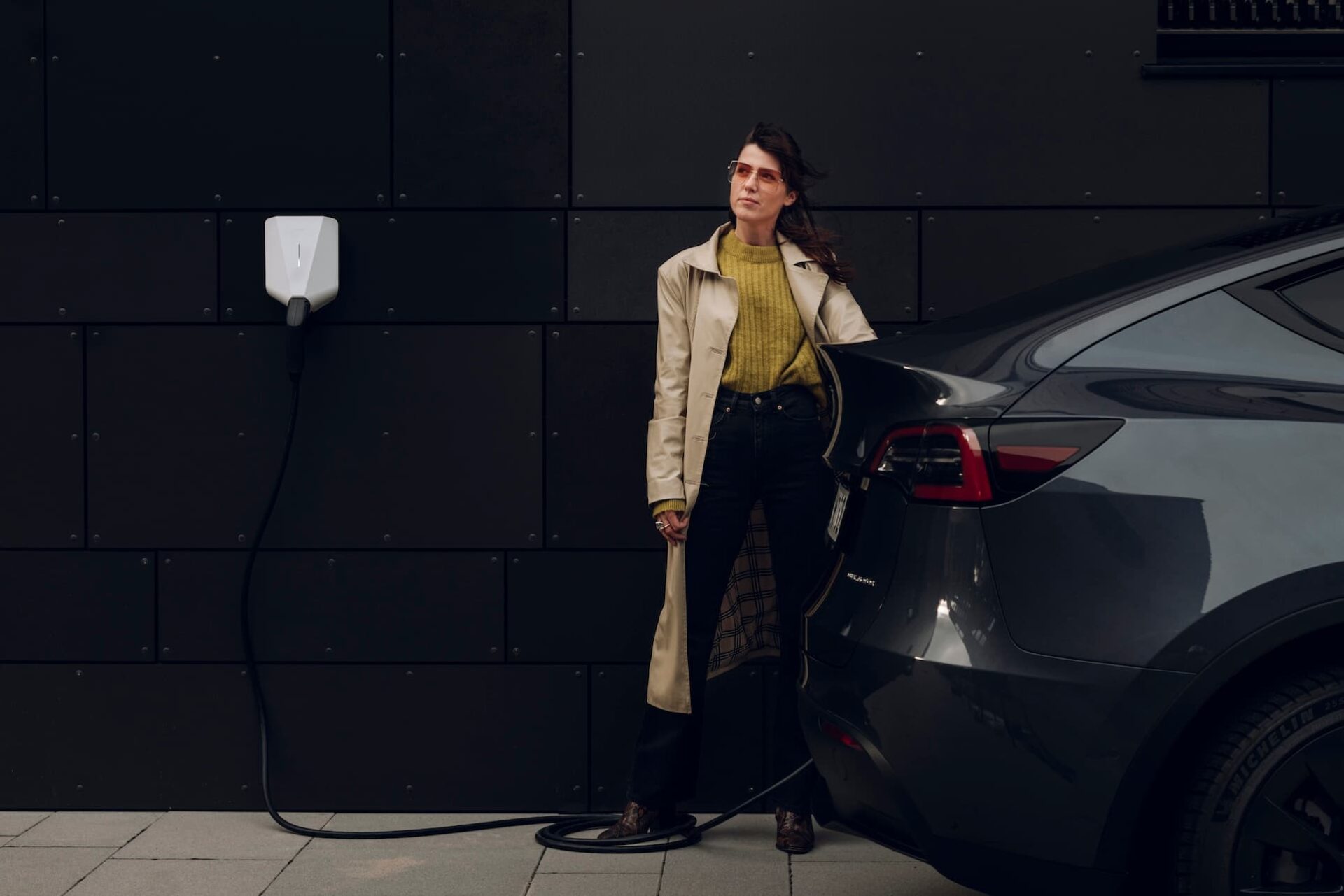 Woman charging her Tesla with a white EV charger