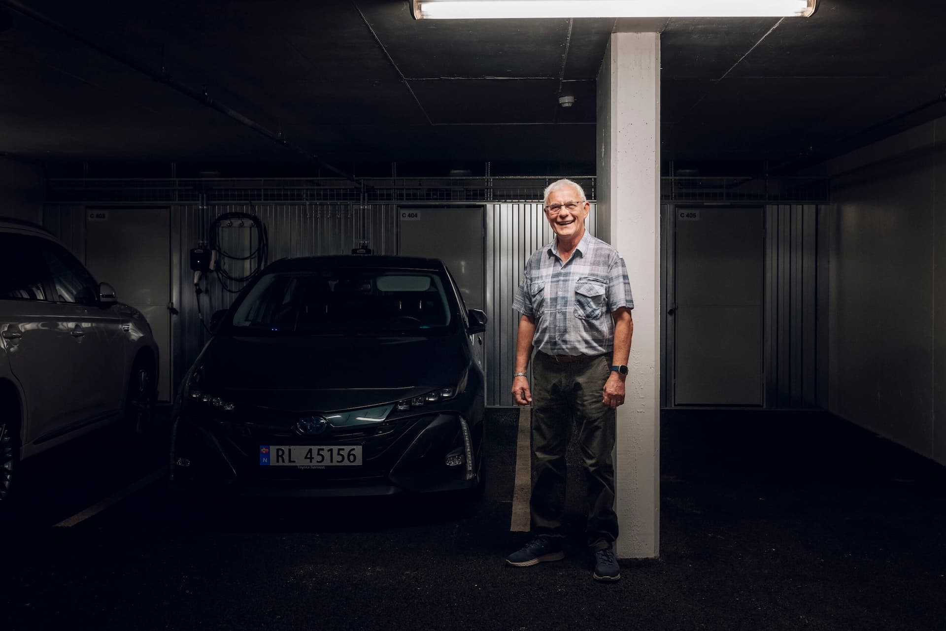 Man standing beside electric car in MDU