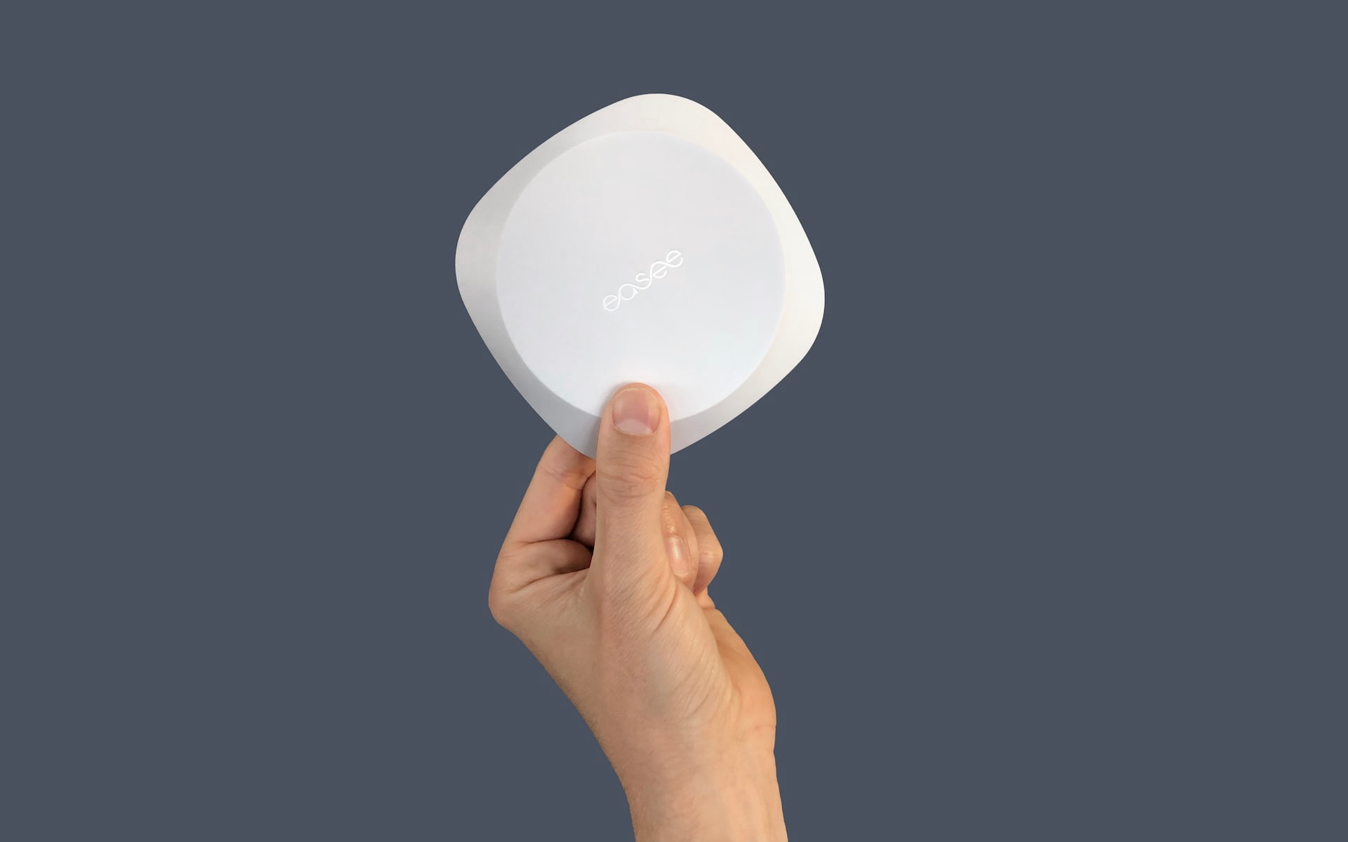 En hånd, der holder Easee Equalizer med to fingre