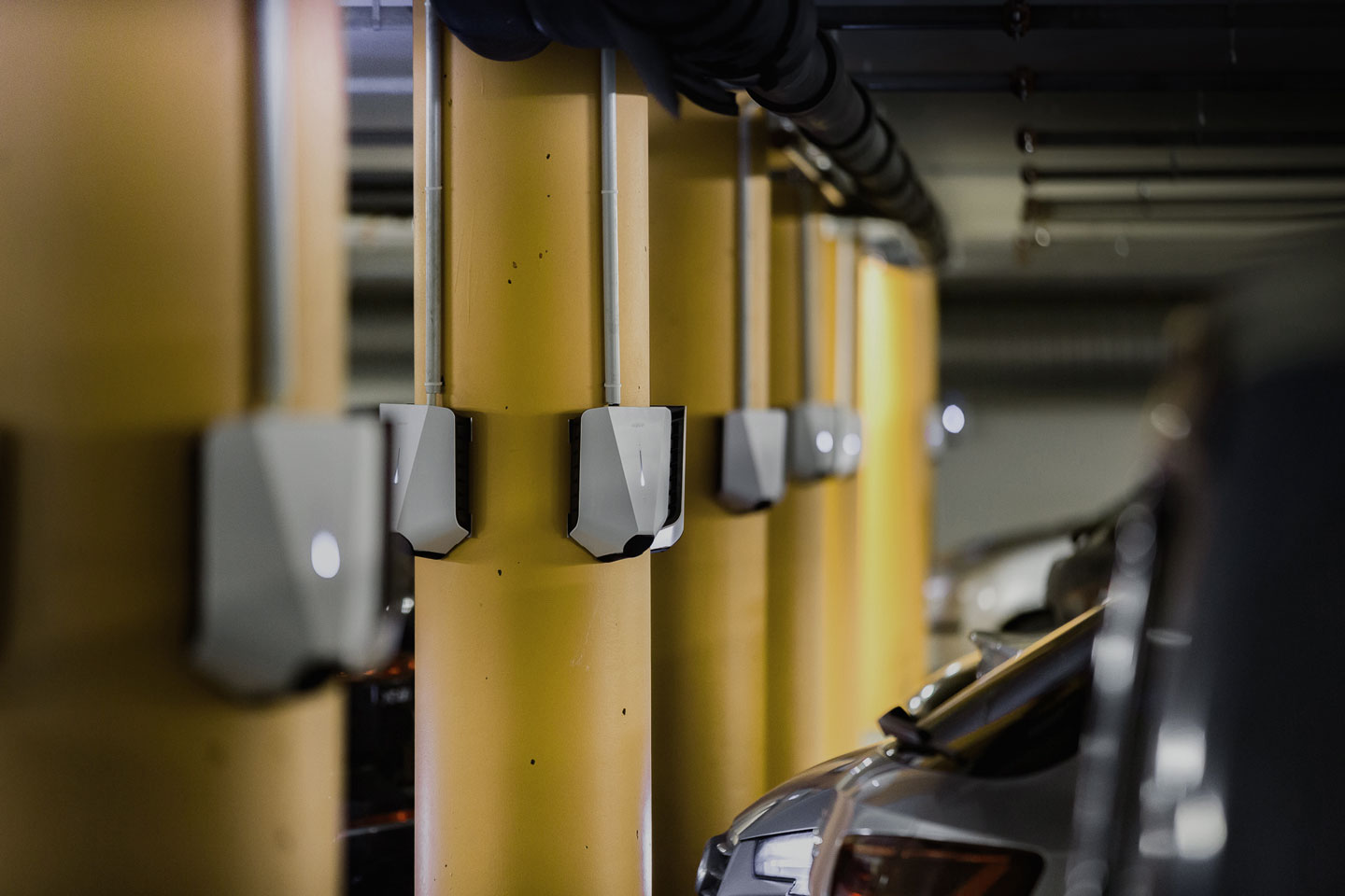 White chargers on yellow poles in car park