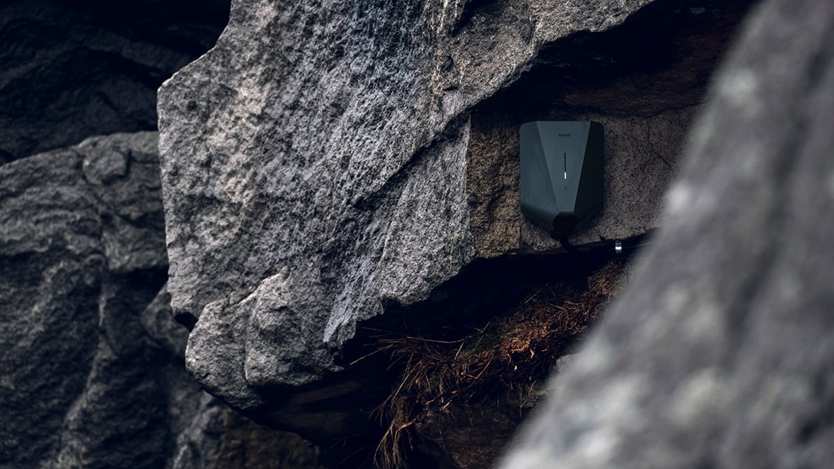 Home EV charger mounted on a rock wall