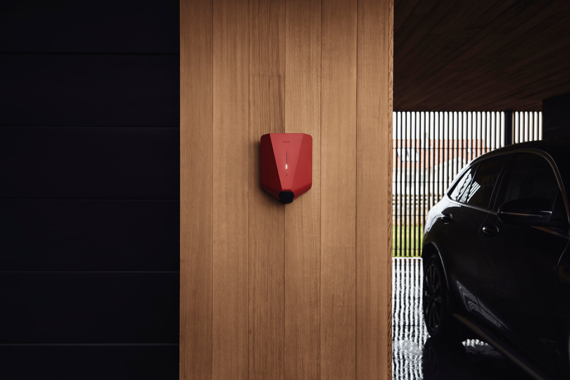 Red electric home EV charger on a wooden wall