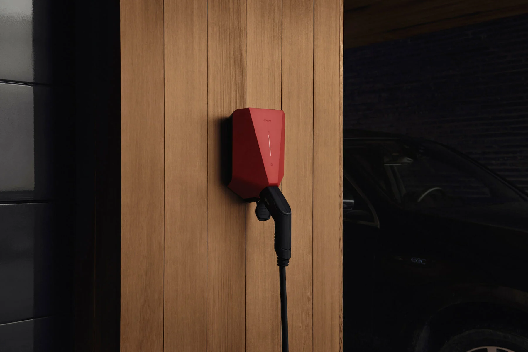 Rød elbillader på trevegg