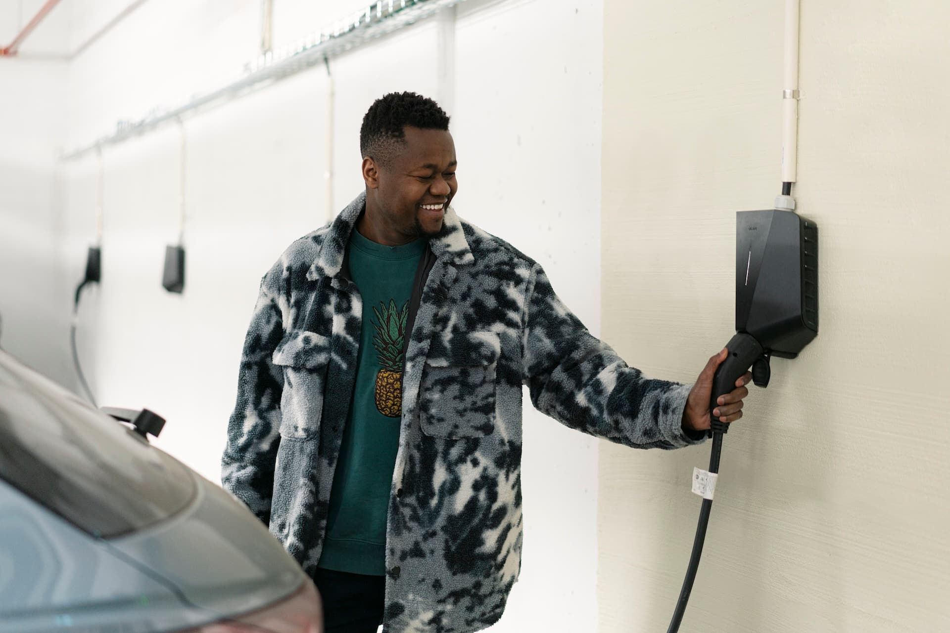 Haji Hassan lader sin elbil i parkeringsanlegget i Frysjaparken