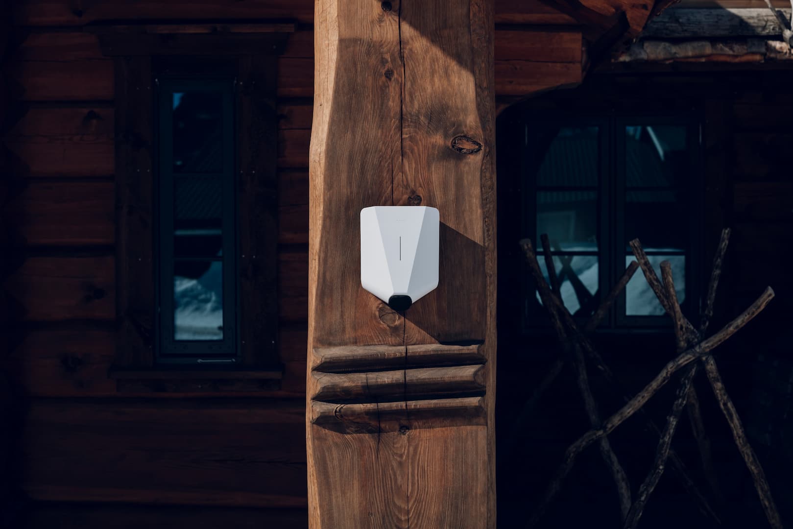 en hvit lader for elbiler på et trehus