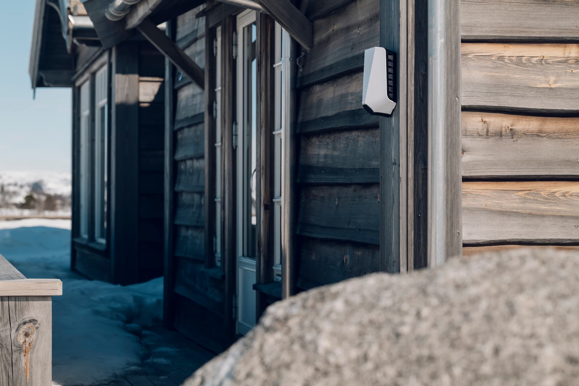 En hvit lader på en vinterhytte av tre