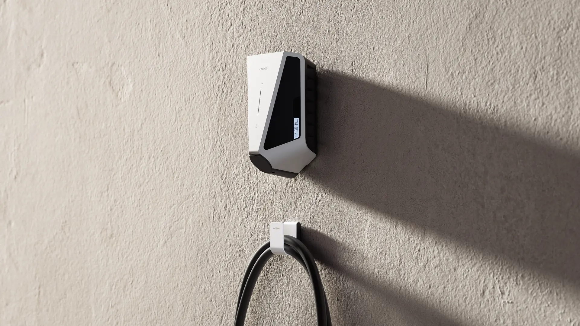 White charger with a small display on a concrete wall with a white U-hook and charging cable