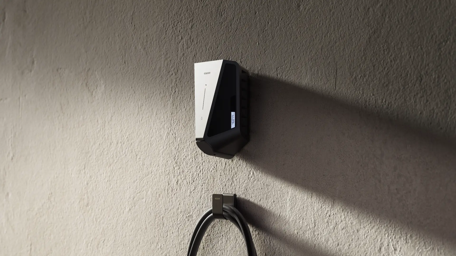 Borne de recharge électrique noire avec un petit écran avec compteur électrique, montée sur un mur en béton. Avec le U-Hook et un câble de recharge.